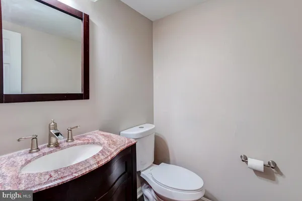 a bathroom with a granite countertop toilet sink and mirror