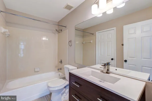 a bathroom with a sink a toilet a large mirror and shower