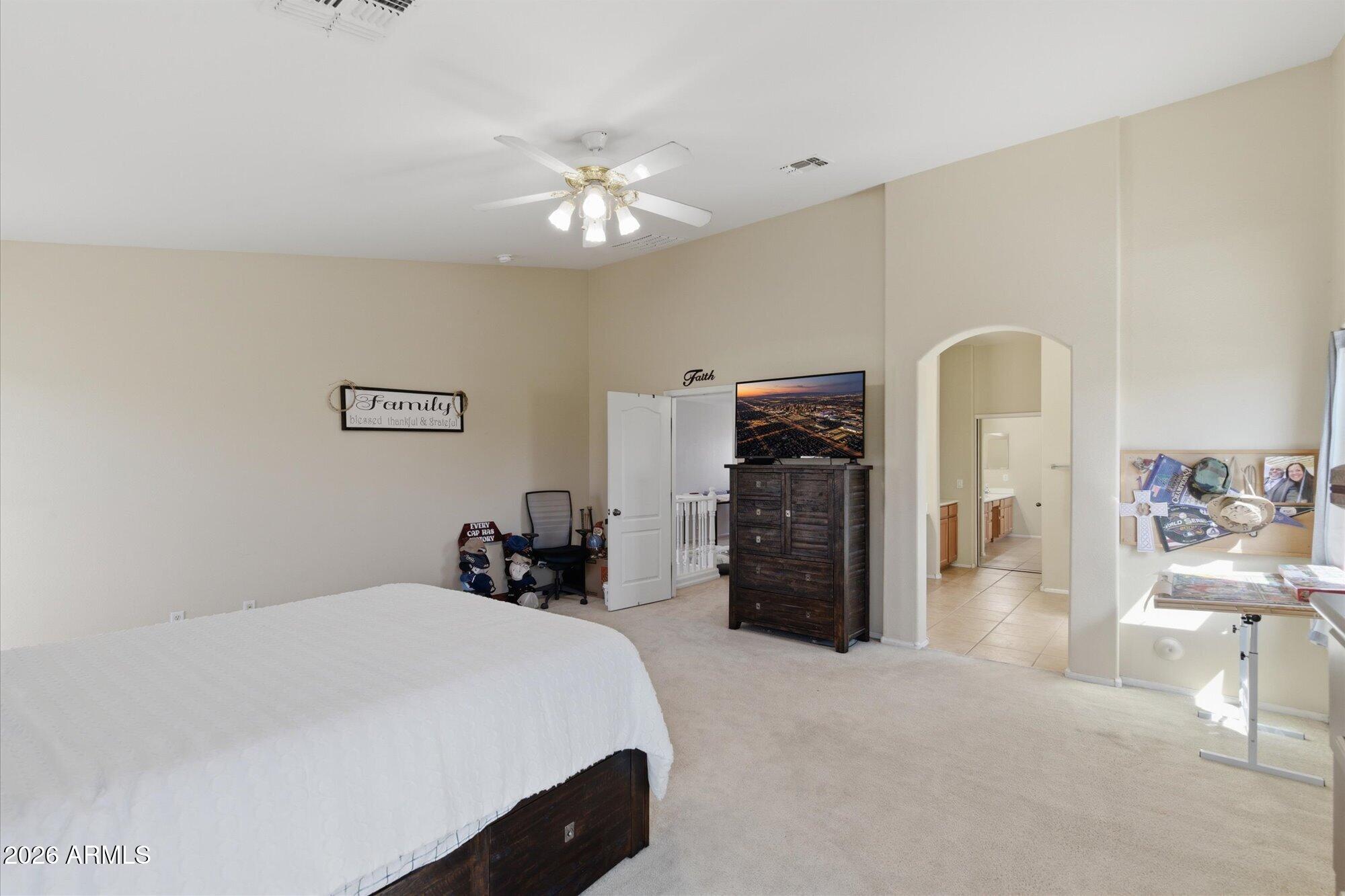 21915 Dietz Drive Maricopa, AZ 85138 - Photo 16 of 31 a bedroom with a bed and a chandelier