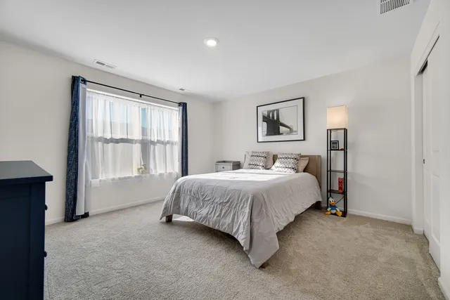 a spacious bedroom with a bed and a window