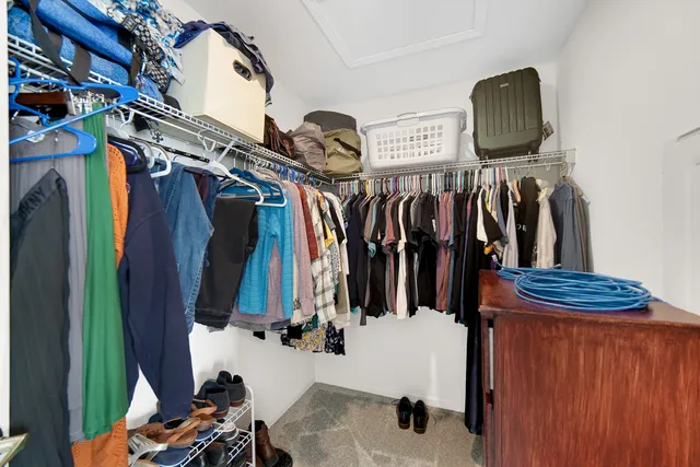 a view of walk in closet with clothes