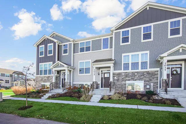 a front view of a house with a yard and plants