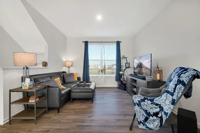 a living room with furniture and a wooden floor