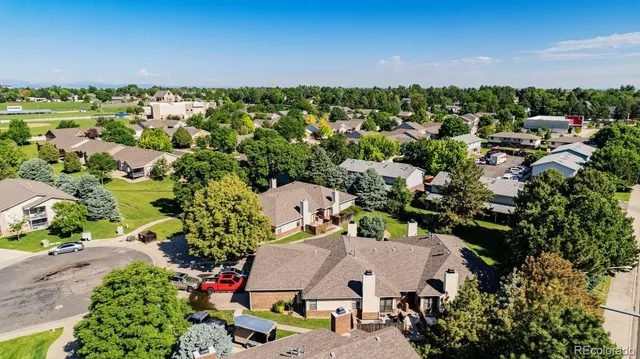 an aerial view of residential houses with outdoor space and trees