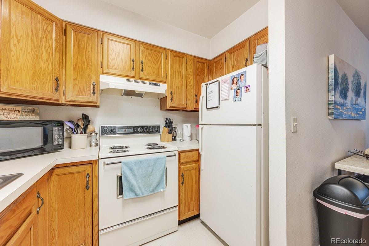 2166 35th Ave Court, Unit 14 Greeley, CO 80634 - Photo 14 of 33 a kitchen with a refrigerator a stove a sink and a cabinets
