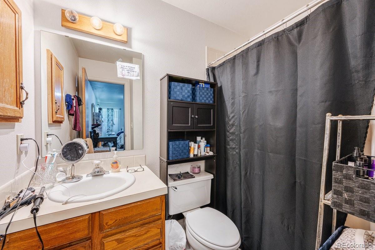 2166 35th Ave Court, Unit 14 Greeley, CO 80634 - Photo 20 of 33 a bathroom with a sink a toilet and shower curtain