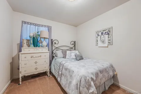 a bedroom with a bed and a potted plant on dresser