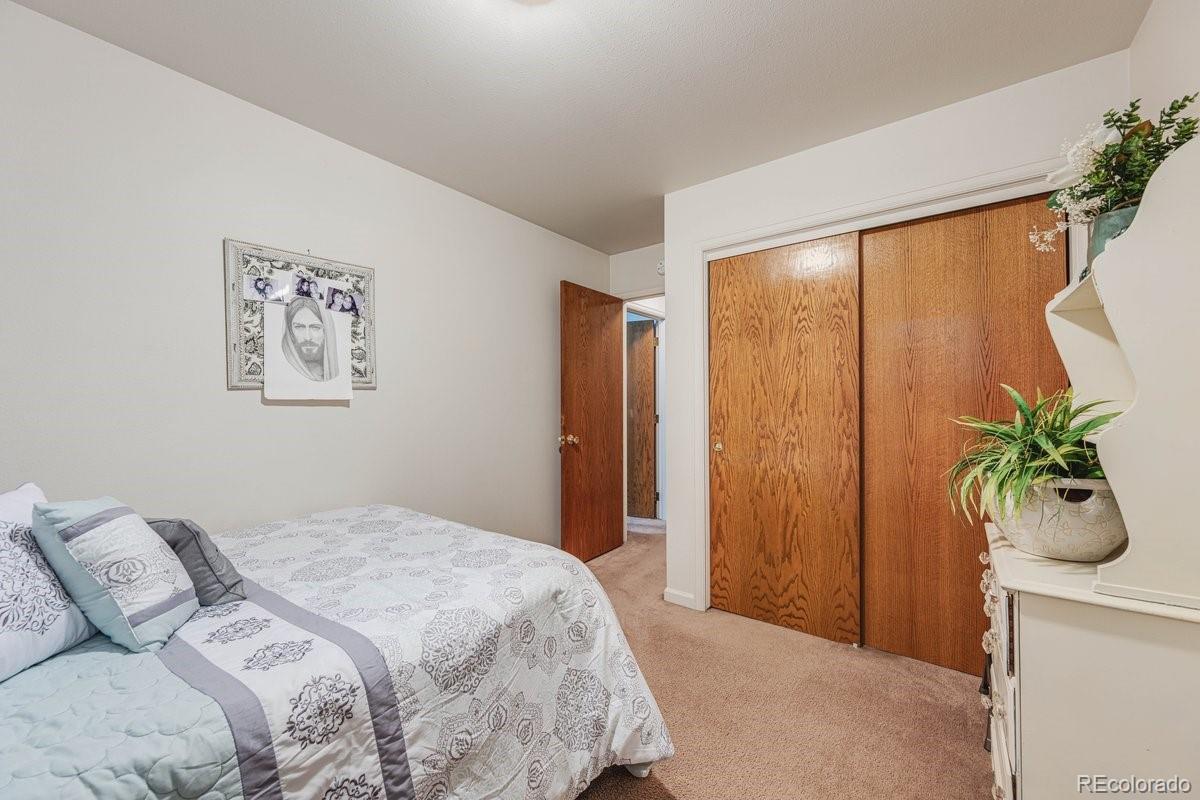 2166 35th Ave Court, Unit 14 Greeley, CO 80634 - Photo 22 of 33 a bedroom with a large bed and a potted plant