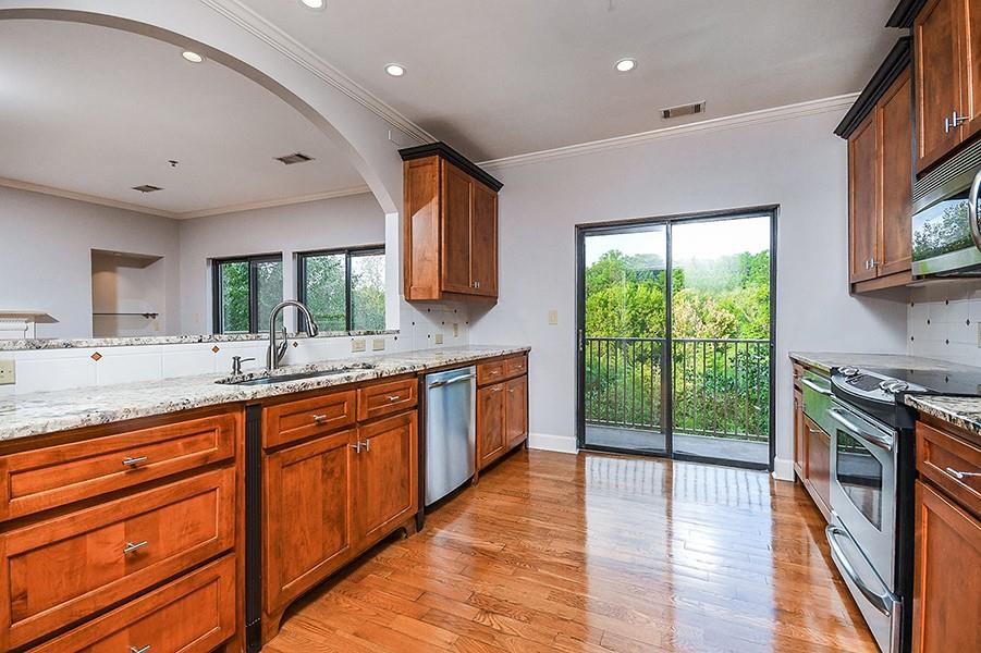 2865 Lenox Road Northeast, Unit 407 Atlanta, GA 30324 - Photo 11 of 27 a large kitchen with stainless steel appliances granite countertop a stove a sink and a refrigerator
