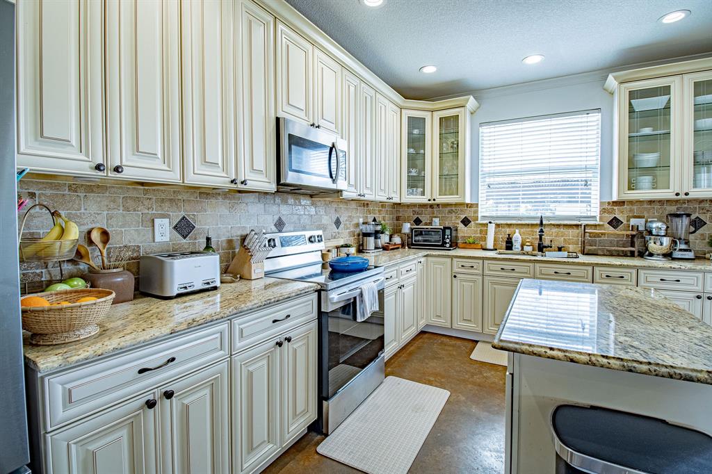 328 Meadow Lane Red Oak, TX 75154 - Photo 7 of 35 Kitchen featuring stainless steel appliances, light stone countertops, tasteful backsplash, recessed lighting, and a textured ceiling
