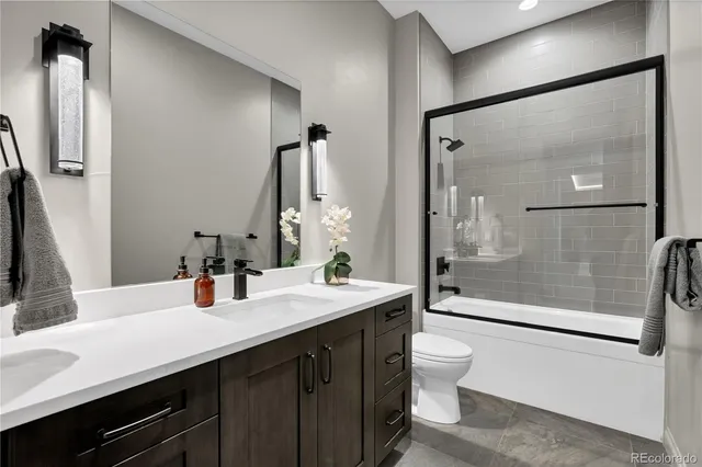 a bathroom with a double vanity sink toilet mirror and shower