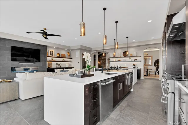 a large kitchen with stainless steel appliances kitchen island granite countertop a stove top oven a sink a dining table and chairs with the view