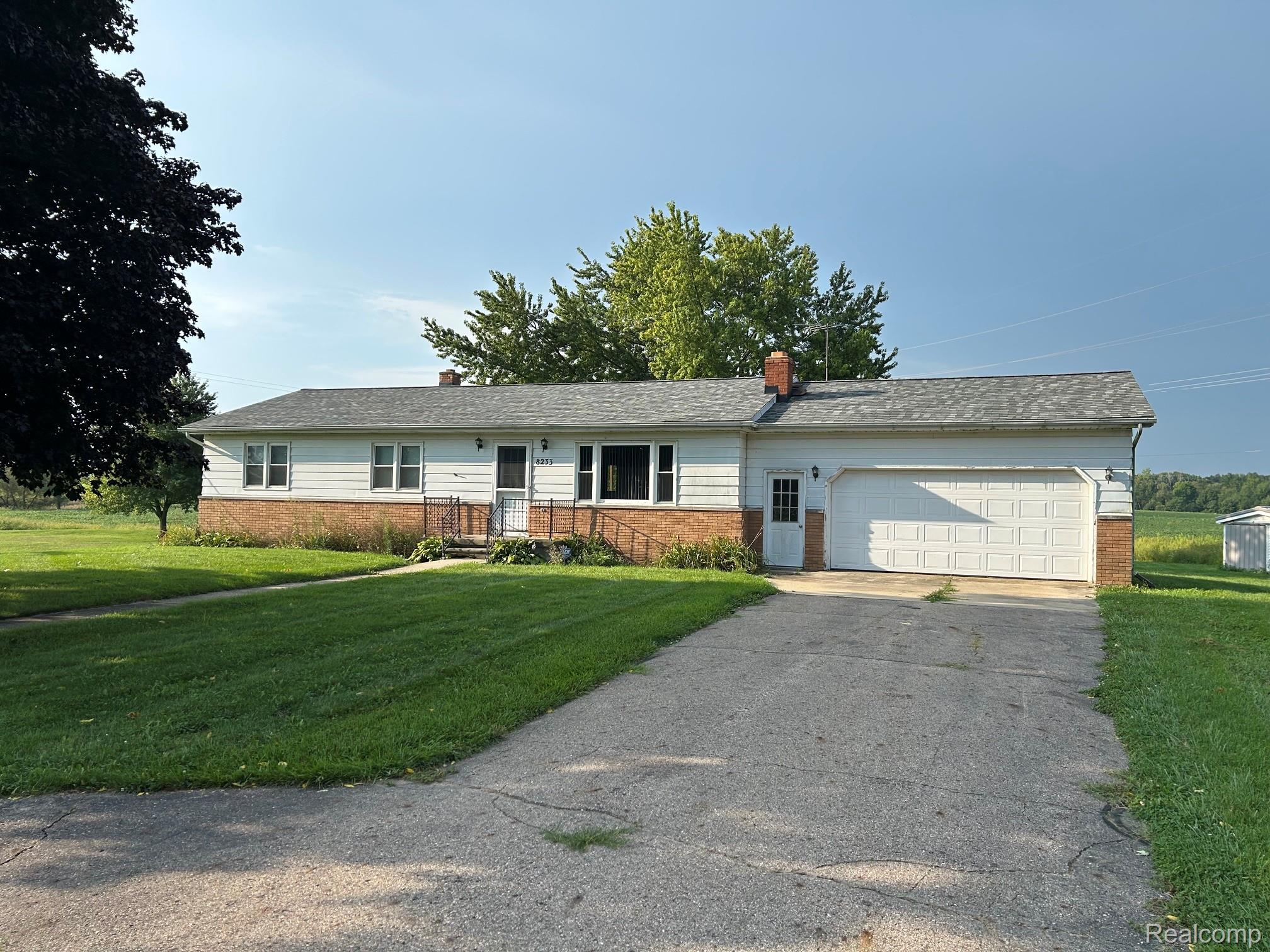 8233 West Iosco Road Fowlerville, MI 48836 - Photo 1 of 7 Ranch-style residence featuring a white siding exterior and brick accents