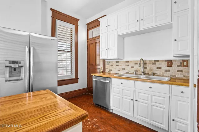 an empty room with wooden floor closet and windows