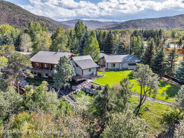 an aerial view of a house with a garden and swimming pool