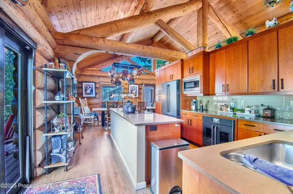 a kitchen with stainless steel appliances granite countertop a sink refrigerator and cabinets