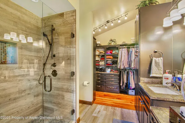 a bathroom with a granite countertop shower a mirror and a sink