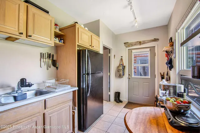 a kitchen with stainless steel appliances granite countertop a sink refrigerator and cabinets