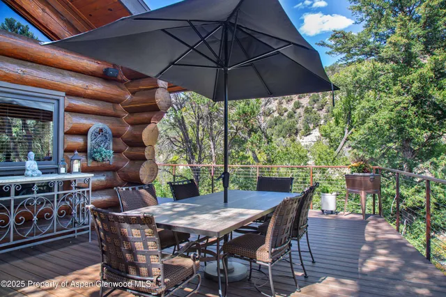 a patio with wooden floor a yard a table and chairs