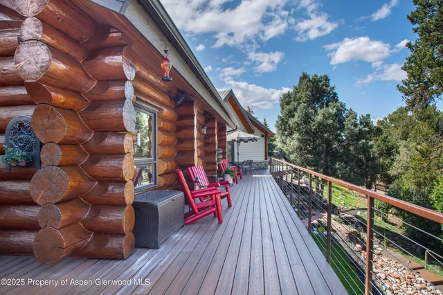 a balcony with wooden floor and outdoor seating