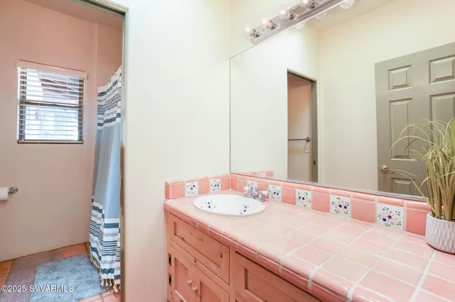 a view of a white house next to a yard with plants and trees