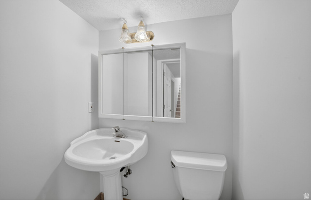 883 East 700 South Springville, UT 84663 - Photo 40 of 59 Pedestal sink with chrome faucet, flanked by a mirrored medicine cabinet and a two-bulb wall sconce