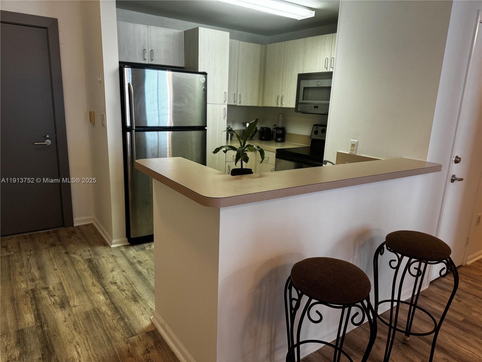 185 Southeast 14th Terrace, Unit 1812 Miami, FL 33131 - Photo 3 of 10 a kitchen with stainless steel appliances granite countertop a refrigerator a stove a sink and a refrigerator