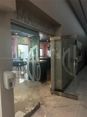 a living room with couches and kitchen view with wooden floor