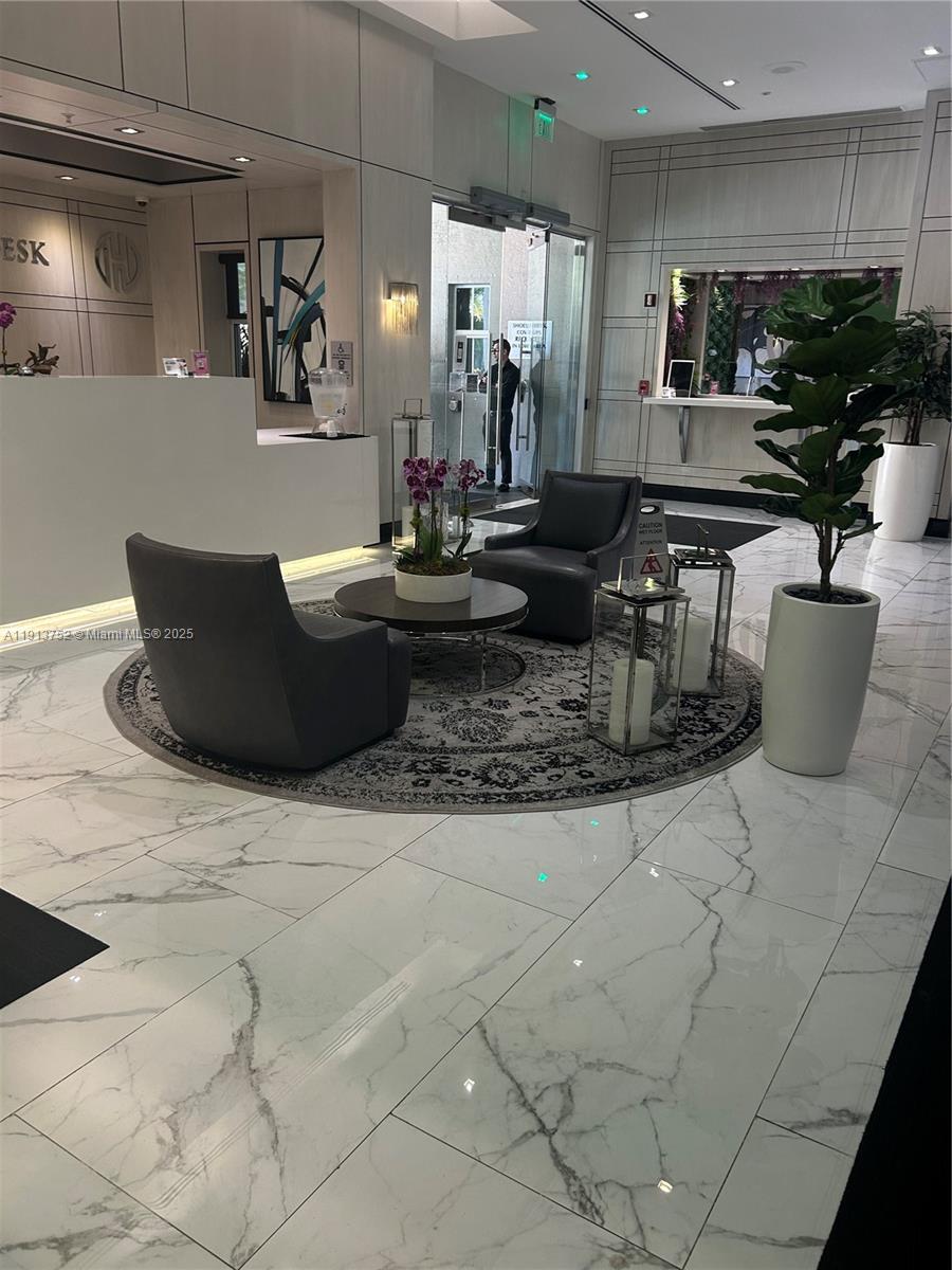 185 Southeast 14th Terrace, Unit 1812 Miami, FL 33131 - Photo 9 of 10 a living room with couches and kitchen view with wooden floor