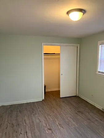 an empty room with wooden floor and closet