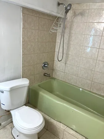 a white toilet and tub sitting next to a bathroom sink