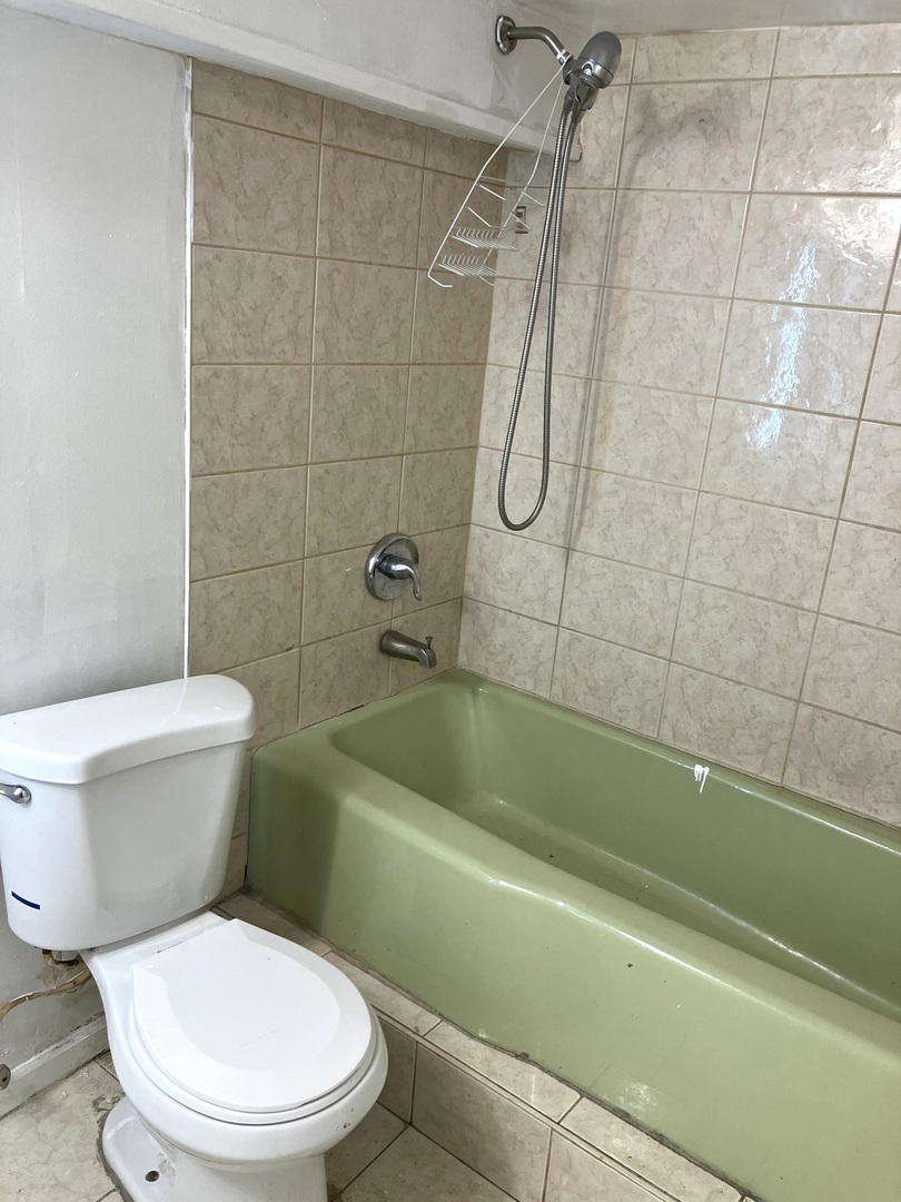 840 East 89th Street Chicago, IL 60619 - Photo 16 of 27 a white toilet and tub sitting next to a bathroom sink