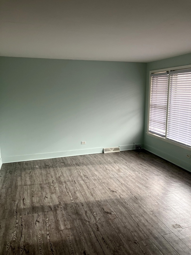 840 East 89th Street Chicago, IL 60619 - Photo 3 of 27 an empty room with wooden floor and windows