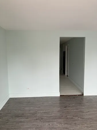 a view of an empty room and wooden floor
