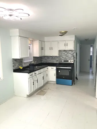 a large kitchen with stainless steel appliances granite countertop a stove and cabinets