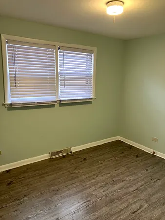 a view of a room with wooden floor and a window