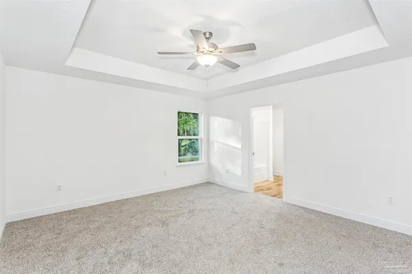 an empty room with a ceiling fan and window