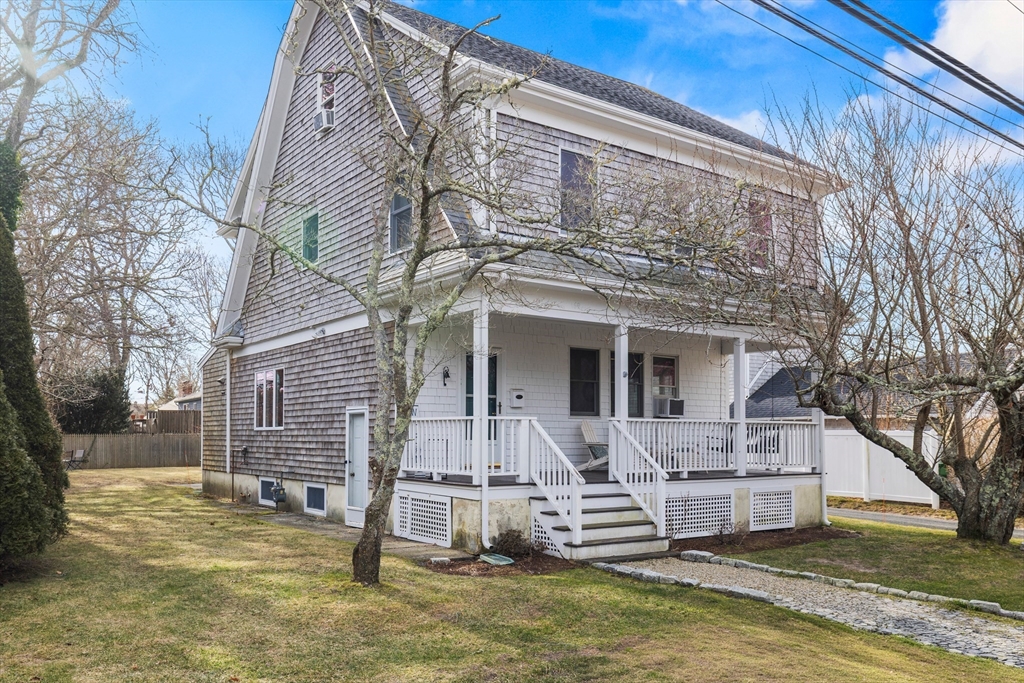 a view of a house with a yard chairs and iron fence