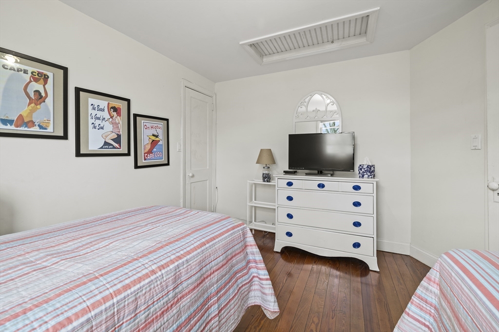 169 Gosnold Street Barnstable, MA 02601 - Photo 23 of 40 a bedroom with a bed and flat tv screen on the dresser
