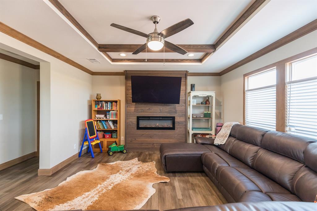 10099 County Road 452 Merkel, TX 79536 - Photo 9 of 28 a living room with furniture a fireplace and a ceiling fan