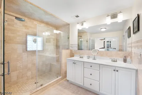 a bathroom with a granite countertop sink mirror and shower