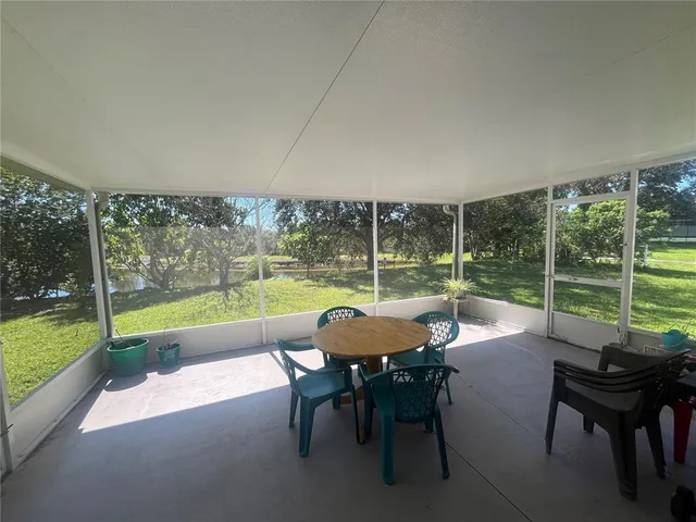 a dining room with furniture and floor to ceiling window