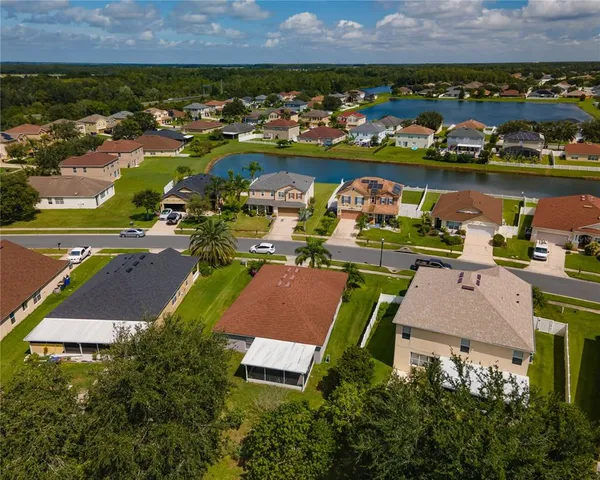 an aerial view of residential houses with outdoor space and lake view