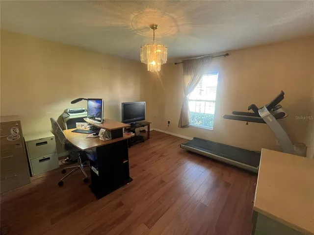 a view of a workspace with furniture and a window