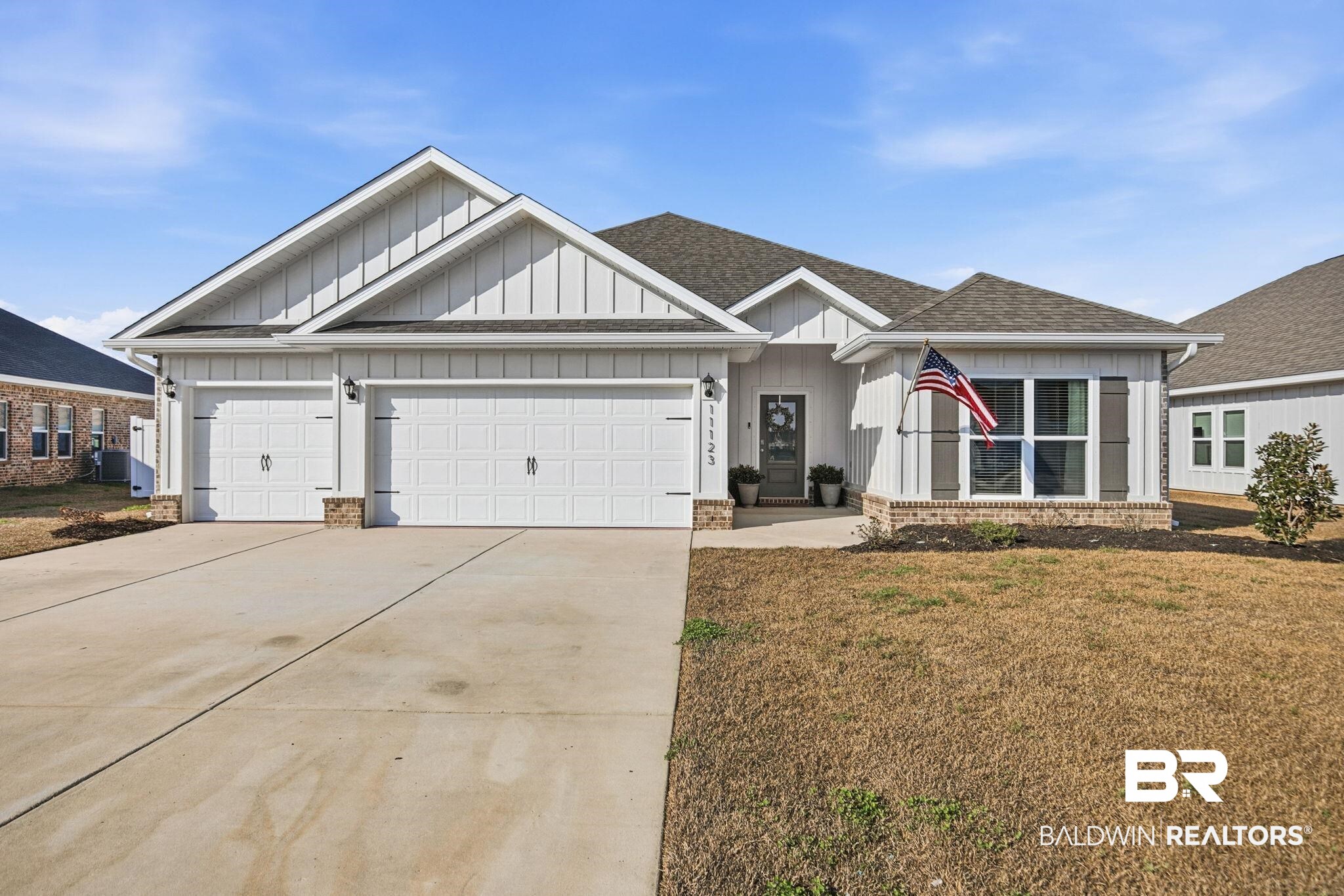 11123 Genuine Risk Circle Daphne, AL 36526 - Photo 3 of 67 View of front of home with board and batten siding, concrete driveway, an attached garage, a shingled roof, and a front lawn