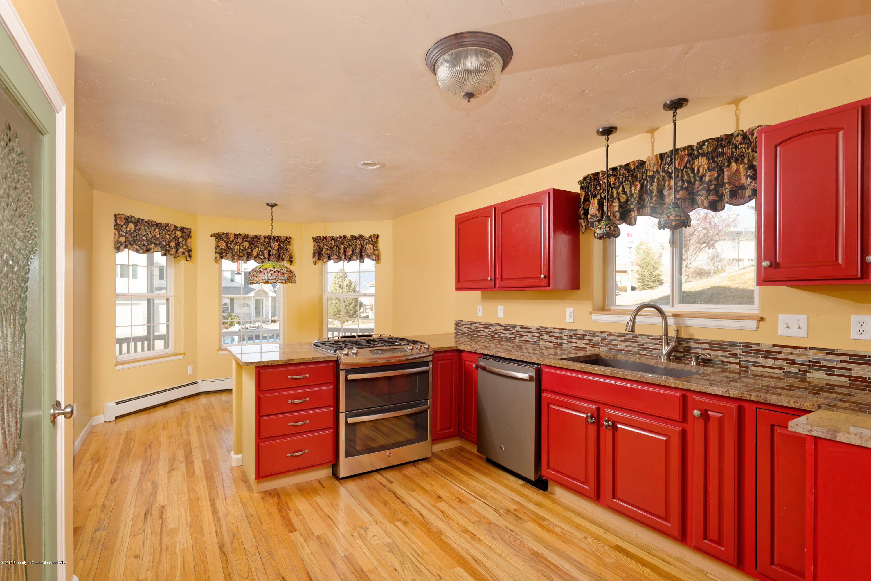 1371 Firethorn Drive Rifle, CO 81650 - Photo 5 of 16 a kitchen with stainless steel appliances granite countertop a sink stove and wooden cabinets