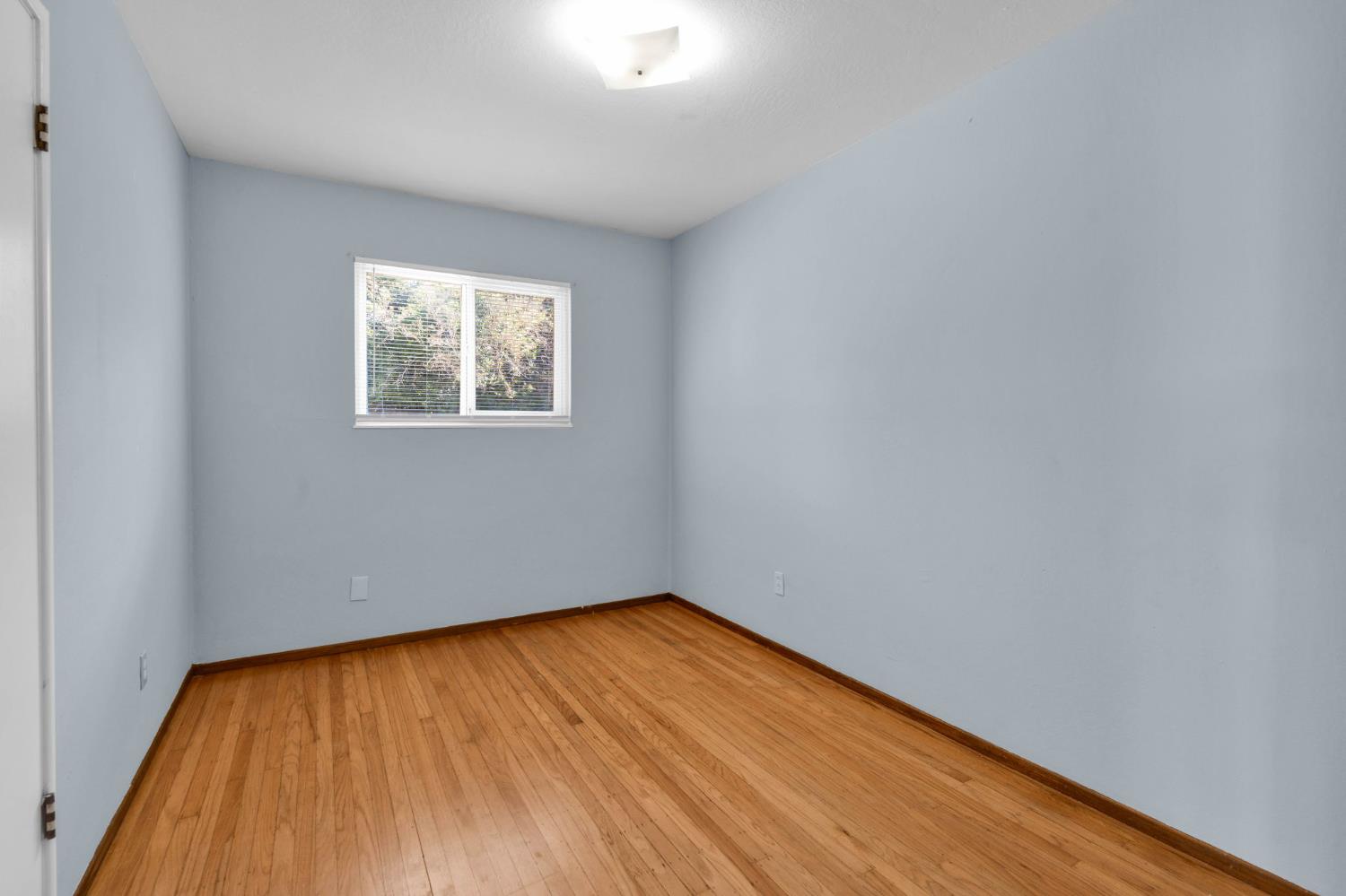 1714 Pole Line Road Davis, CA 95618 - Photo 13 of 24 a view of an empty room with wooden floor and a window