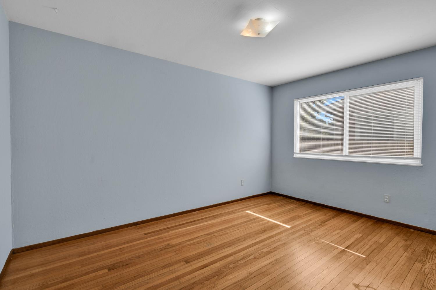 1714 Pole Line Road Davis, CA 95618 - Photo 10 of 24 a view of an empty room with wooden floor and a window