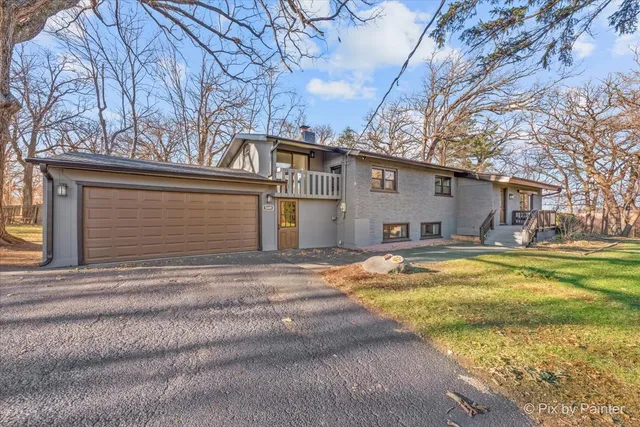 a view of a house with a yard and large tree