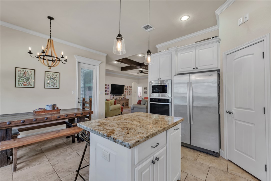 8312 Raintree Drive College Station, TX 77845 - Photo 13 of 30 Kitchen island with granite countertop, white cabinetry, stainless steel appliances, and recessed lighting